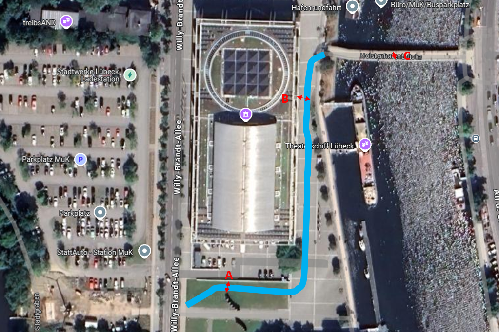 Auf einem Luftbild ist der Streckenverlauf des Radwegs von der Stadtgrabenbrücke zur Holstenhafenbrücke südlich und östlich der MuK eingezeichnet.