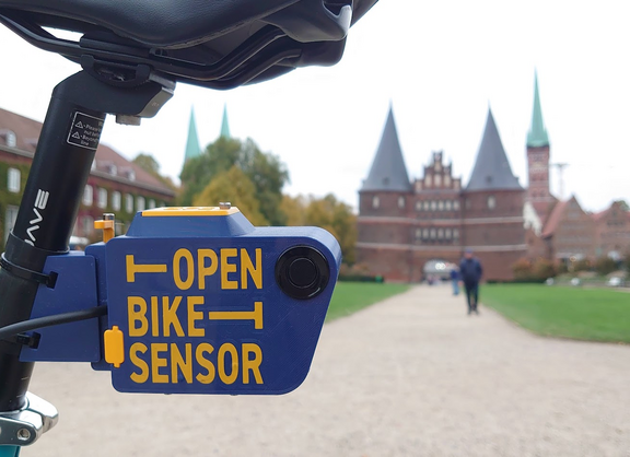 Ein Fahrrad mit einem an der Sattelstütze montierten Open Bike Sensor steht vor dem Holstentor