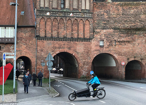 Schwarzes Lastenrad vor dem Burgtor