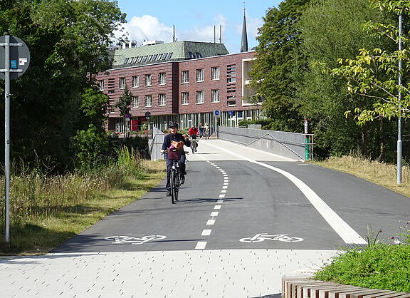 Das Foto zeigt Radfahrer*innen und Zufußgehende, die die neue Stadgrabenbrücke stadteinwärts nutzen.