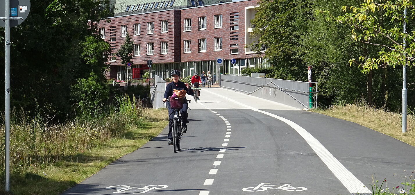 Stadtgrabenbrücke Lübeck Das Foto zeigt Radfahrer*innen und Zufußgehende, die die neue Stadgrabenbrücke stadteinwärts nutzen.