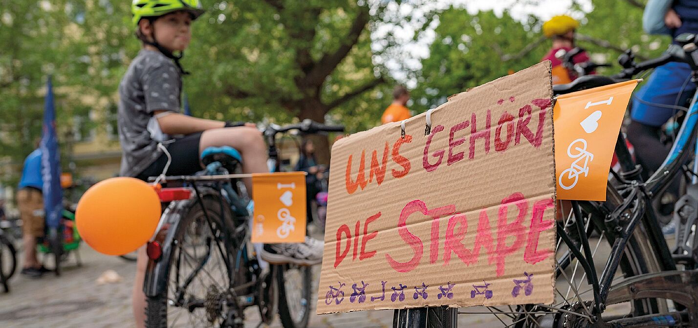 Kidcial Mass Anzeigenmotiv Kind mit Fahrrad und Protestschild